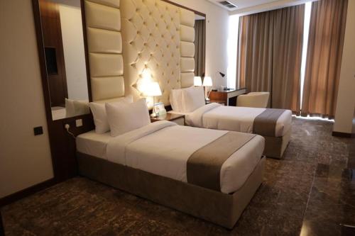 科威特Dolphin Continental Hotel的酒店客房配有两张床和一张书桌