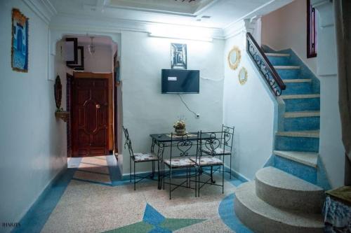 舍夫沙万Chez laasri的走廊设有楼梯和带电视的桌子