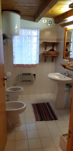 拉马格德莱伊内Casetta con camino的浴室设有2个卫生间、水槽和窗户。