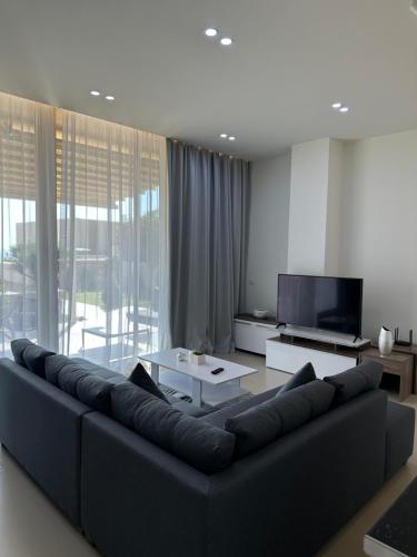 德尔米Green Coast Resort Vila 143B的客厅配有黑色沙发和电视