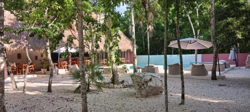 ChemuyilMagic Xcacel Tulum的一个带遮阳伞和椅子的度假村和一个游泳池