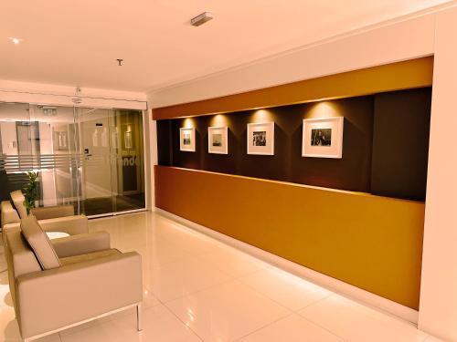 巴西利亚库比契克广场酒店的一间设有椅子和墙上照片的等候室
