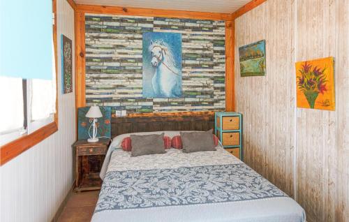 Los Puertos1 Bedroom Lovely Home In Los Puertos De Arriba的卧室配有一张床,墙上挂有绘画作品