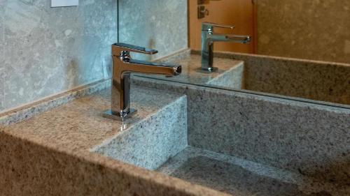 萨利诺波利斯SALINAS PREMIUM RESORT的浴室水槽设有2个水龙头和镜子