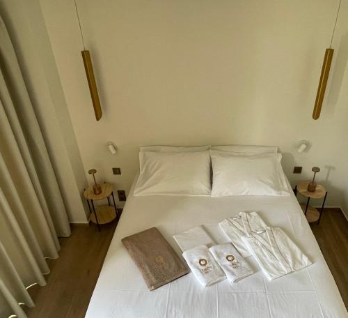 撒尼海滩Oikos Sani Suites的一张白色的床,上面有两条毛巾