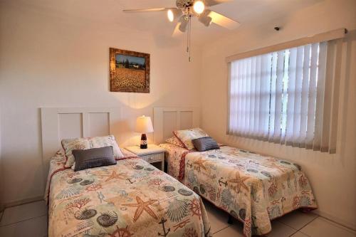 塔维涅2306 Ocean Pointe的一间卧室设有两张床、一盏灯和一扇窗户。
