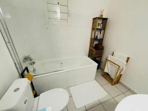 哥西尔Bel appartement cosy - Les pieds dans l'eau的浴室配有白色浴缸和卫生间。
