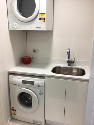 新普利茅斯Beachside studio的厨房配有水槽和洗衣机