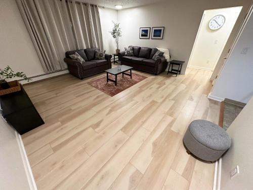 安克雷奇Stay Anchorage! Furnished Two Bedroom Apartments With High Speed WiFi的客厅铺有木地板,配有沙发。