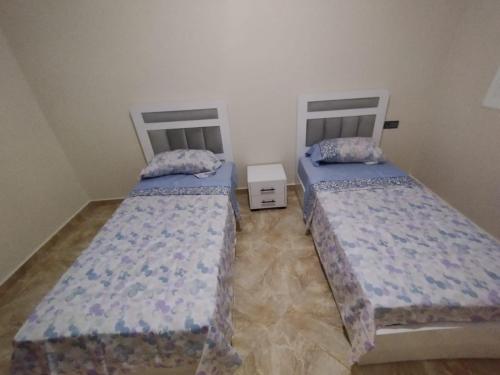 appartement joliment meublé pour 4/5 personnes à Imzouren的两张睡床彼此相邻,位于一个房间里