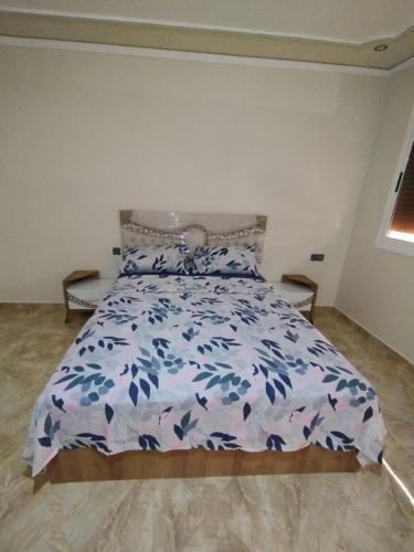 appartement joliment meublé pour 4/5 personnes à Imzouren的一间卧室配有一张带蓝色和白色床单的床。