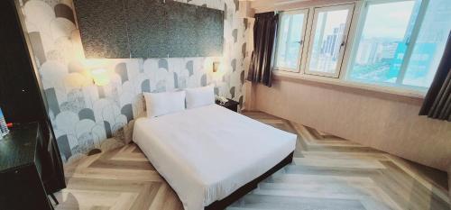 台北Gugis Inn 的一间小卧室,配有白色的床,位于带窗户的房间内