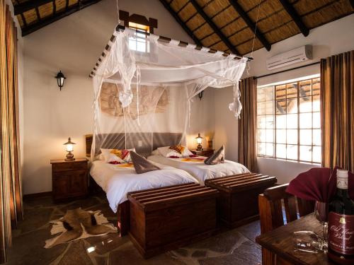 KanebisGondwana Canyon Village的一间卧室配有一张带天蓬的床