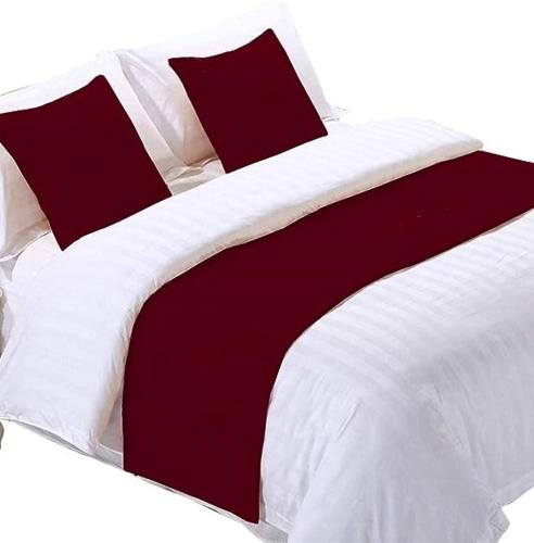 BulbulaWayu Nova Guesthouse的一张大床,配有红色和白色的床单和枕头