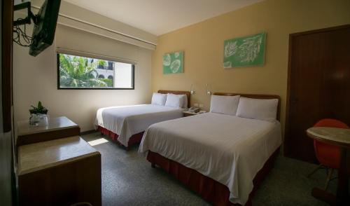 比亚埃尔莫萨Olmeca Plaza Urban Express的酒店客房设有两张床和窗户。