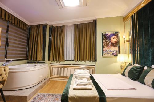 伊斯坦布尔WHITEMOON HOTEL SUİTES的一间卧室配有浴缸和带毛巾的床。