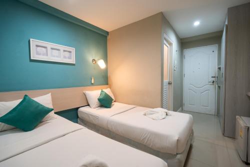 合艾V海洋宫殿酒店的蓝色墙壁客房的两张床