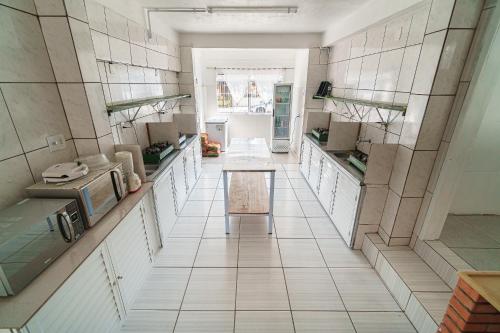 托雷斯Parada da Cal Beach Torres的一间大厨房,配有白色的橱柜和一张桌子