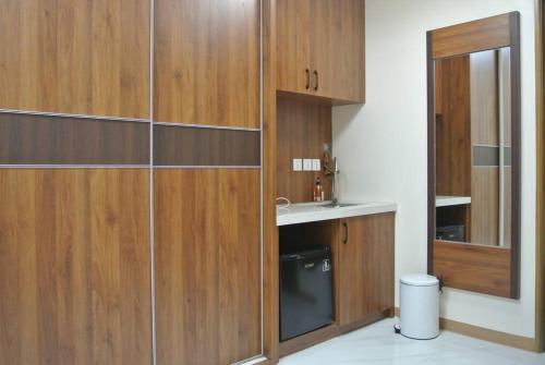 马尼拉Beachside Embassy Apartment的一间带木制橱柜、水槽和卫生间的浴室
