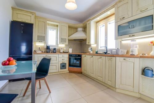 VívlosDaphne's place的厨房配有白色橱柜和蓝色桌子