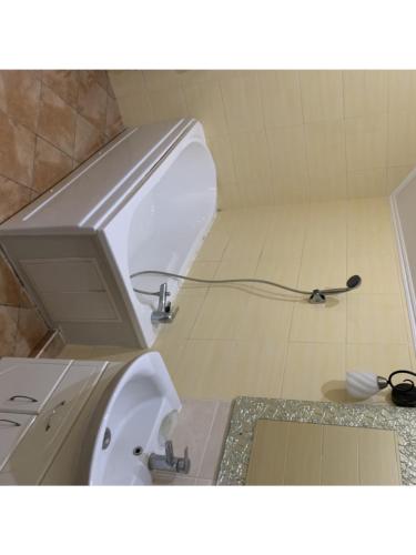 HoraФИЕСТА的浴室内设有一个白色的卫生间,配有软管