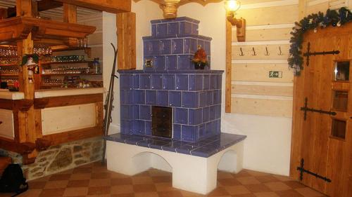 捷克布杰约维采赫尔斯基斯登波幅卡酒店的一间客厅,客厅内配有蓝色瓷砖壁炉