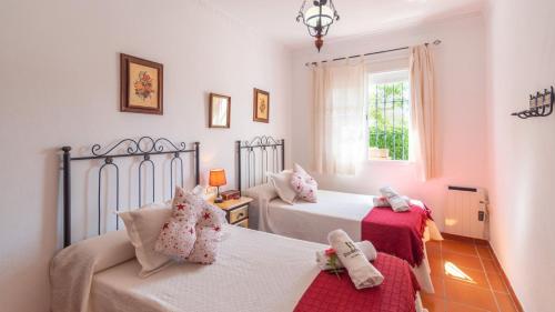 隆达Casa Rural Marquez Ronda by Ruralidays的一间卧室设有两张床、一张沙发和一个窗口