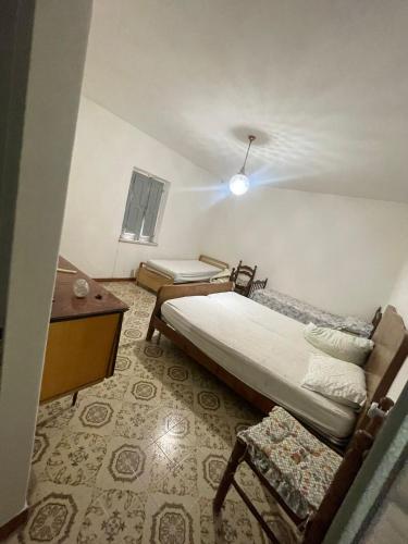 Piciniscola casa nel bosco的小房间设有床、书桌和床筒