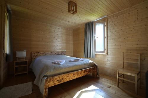 MazeriCottages SHIKHRA - კოტეჯები შიხრა的小木屋内一间卧室,配有一张床