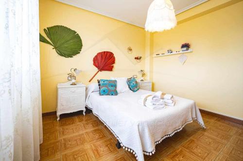 CandanalLa Huertina De Granda的一间卧室配有一张带白色毯子和蓝色枕头的床。