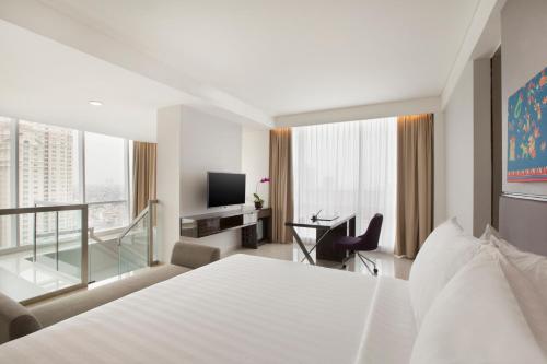 雅加达萨提卡高级哈亚乌鲁雅加达酒店的酒店客房配有一张床、一张书桌和一台电视。