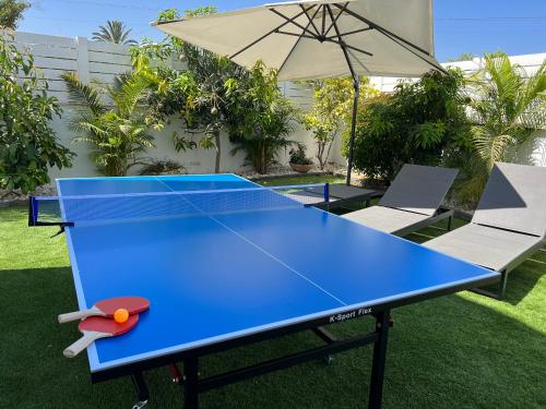 里雄莱锡安Lux & Comfy ~ Pool ~ Queen Beds的院子里的蓝色乒乓球桌,带雨伞