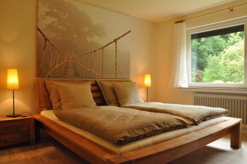 吕格德Ferienwohnung Amselnest的卧室配有一张床铺,墙上挂有桥画