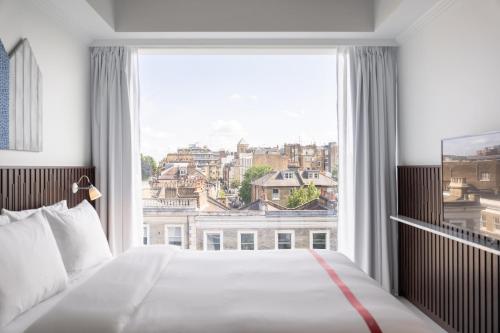 伦敦Ruby Zoe Hotel London的卧室设有大窗户,享有城市美景