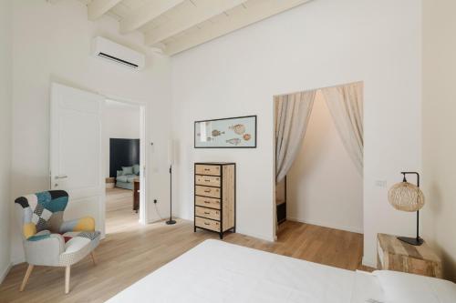 卡洛福泰BassaMarea - Una sorpresa in Centro storico的白色卧室配有床和椅子