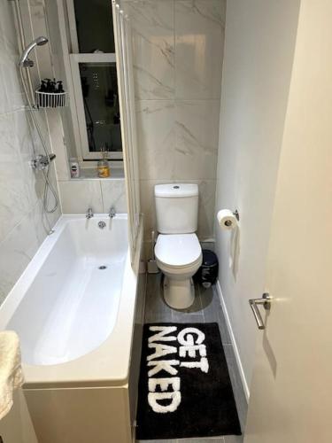 布莱顿霍夫Studio Apartment In Brighton & Hove的浴室配有白色浴缸、卫生间和地毯。
