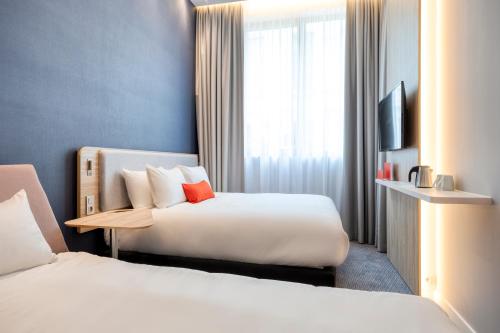 安特卫普Holiday Inn Express Antwerp - City Centre, an IHG Hotel的酒店客房设有两张床和电视。