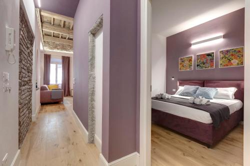 佛罗伦萨Mamo Florence - Aperol & Spritz Apartments的一间卧室设有一张紫色墙壁的大床