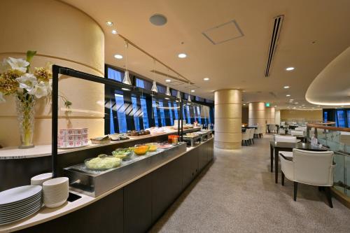 和歌山和歌山城市酒店的一间设有盘子和桌子的自助餐厅
