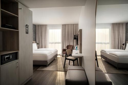罗斯托克Arthotel ANA Amber的酒店客房配有两张床和一张书桌