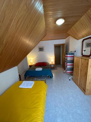 普洛戈la vallee的一间卧室设有两张床和木制天花板