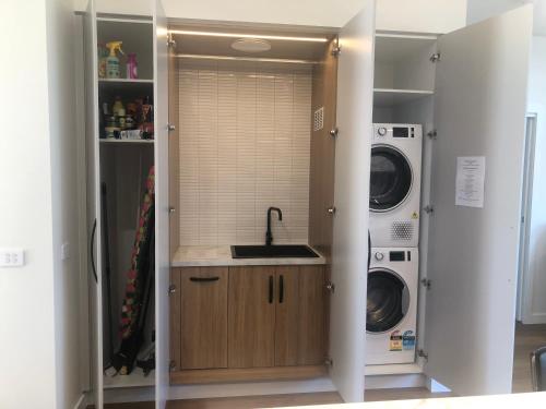 朗塞斯顿Luxe & Superior 2BR Villas Patio Free Parking & Wifi的洗衣房配有水槽、洗衣机和烘干机