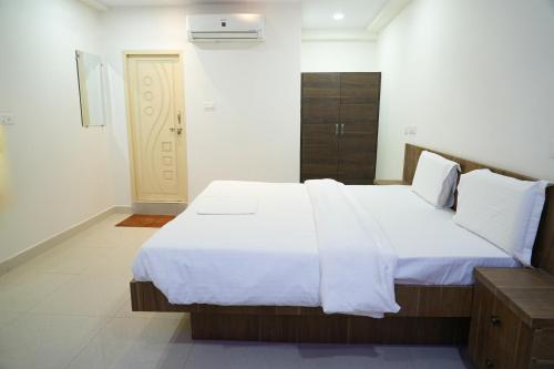 商沙巴5 STAR GRAND- PREMIUM的一间卧室配有一张带白色床单的大床
