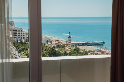 巴统Alliance Palace Aparthotel的从窗口欣赏城市和海洋美景