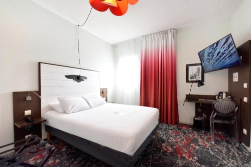 拉罗谢尔拉罗谢尔中心基里雅德酒店的一张床铺、一张桌子和一张床