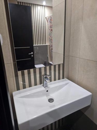 El AouinaBattouta22的浴室设有白色水槽和镜子