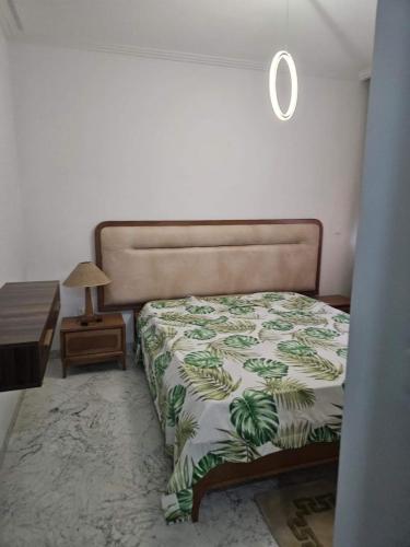 El AouinaBattouta22的一间卧室配有一张带绿色和白色毯子的床