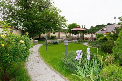 基辅欧萨利亚酒店的花园,花园中拥有小径和鲜花,设有凉亭