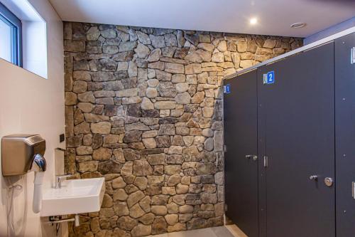 波拉齐克SolinaGlamp的石质浴室设有水槽和石墙