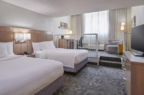 哥伦布哥伦布市区万怡酒店的酒店客房设有两张床和一台平面电视。